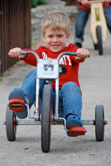 A boy riding a tricycle.